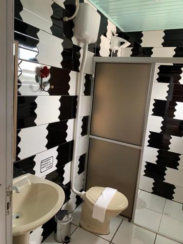 a bathroom with a toilet and a sink at Pousada Deck 950 - Cambará do Sul in Cambará
