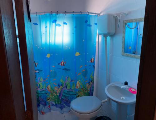 a bathroom with an aquarium shower curtain with a toilet at Casa Beira Mar com Piscina in Rio Grande