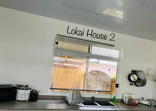 a kitchen window with a london house sign on the wall at Lokai house in Bora Bora