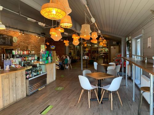 a restaurant with tables and white chairs and lights at Devon Comfort Lodge with Hot Tub - Spa Resort in Devon in Chudleigh
