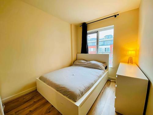 a small bedroom with a bed and a window at Secure 2BR 1BA Apartment for 6 in Colindale