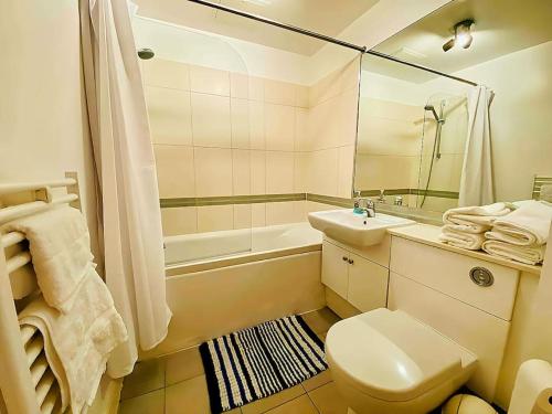 a bathroom with a toilet and a sink and a tub at Secure 2BR 1BA Apartment for 6 in Colindale