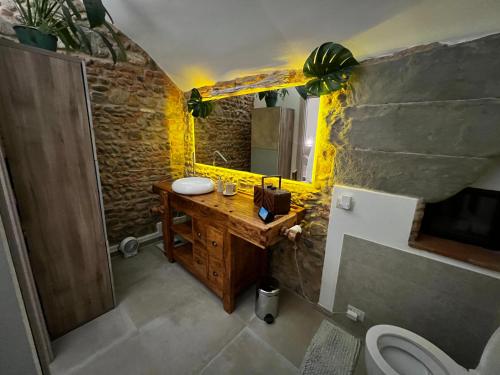 een badkamer met een houten wastafel en een stenen muur bij casatorre medioevale in Campi Bisenzio