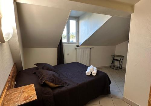 a bedroom with a bed with two teddy bears on it at Hôtel Victor Hugo in Aubervilliers