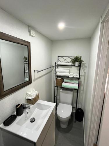 a bathroom with a sink and a toilet and a mirror at Jm.HouseSxm in Koolbaai