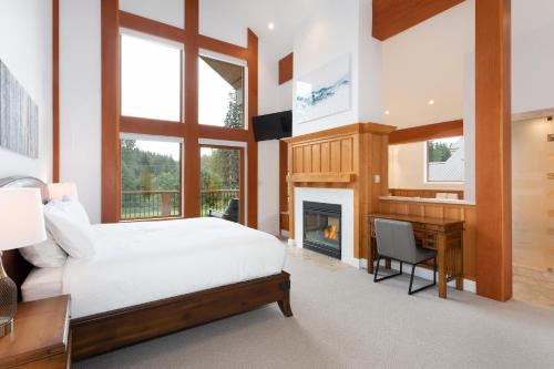 a bedroom with a bed and a desk and a fireplace at Big Sky Chalet - Golf Course chalet, Hot Tub, Theatre, Scenic Views - Whistler Platinum in Whistler