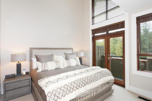 - une chambre blanche avec un lit et une fenêtre dans l'établissement Fitzsimmons Walk 19 - Townhome Near Village, Private Hot Tub & Parking - Whistler Platinum, à Whistler