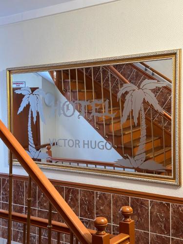 a picture of a staircase with a picture of palm trees at Hôtel Victor Hugo in Aubervilliers