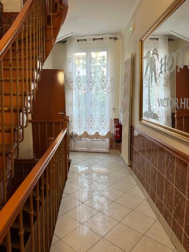 a hallway with a staircase and a window at Hôtel Victor Hugo in Aubervilliers