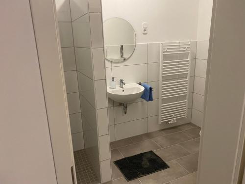 bagno con lavandino e specchio di Appartementhaus EMDEN a Emden