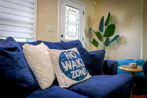 a blue couch with a no wake zone pillow on it at Lakefront Winter Haven Retreat Hot Tub and Patio! in Winter Haven
