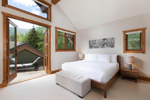 1 dormitorio con 1 cama grande y balcón en Meadow Green Chalet - Family Chalet, Golf Course, Hot Tub, BBQ, Garden - Whistler Platinum, en Whistler