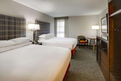 a hotel room with two beds and a television at Drury Inn & Suites St Joseph in Saint Joseph