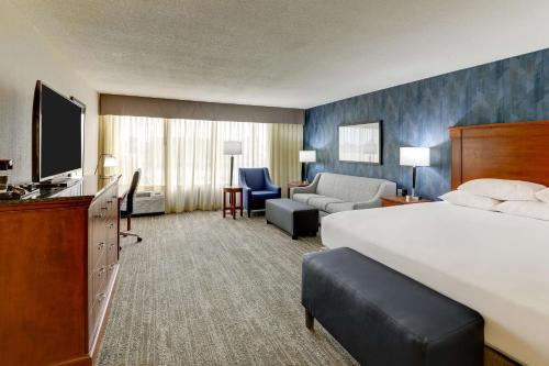 Drury Inn & Suites St. Louis St. Peters في سانت بيترز: غرفه فندقيه سرير كبير وتلفزيون