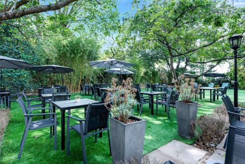 a group of tables and chairs with umbrellas at Doubletree By Hilton London Kensington in London