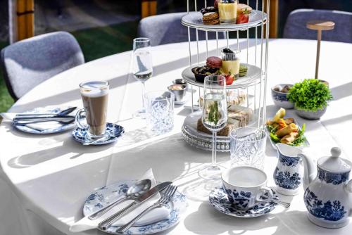 a white table topped with plates of food and drinks at Doubletree By Hilton London Kensington in London
