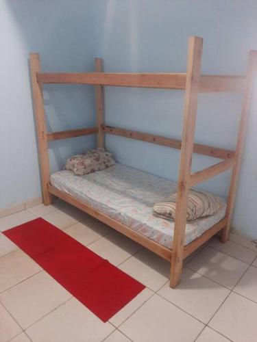 ein Etagenbett aus Holz in einem Zimmer mit einem roten Teppich in der Unterkunft working house in Barueri