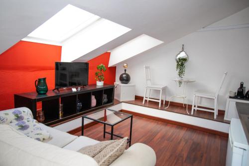 a living room with a white couch and a tv at Hosting Dreams Attics - Duomo in Milan