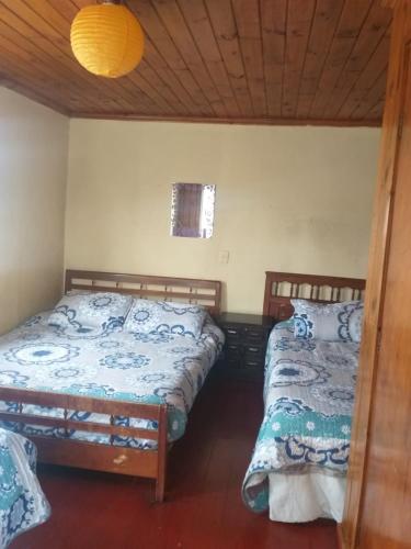 a bedroom with two beds and a window at Hostal playa las conchitas in El Quisco