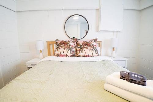 1 dormitorio con 1 cama grande y espejo en Spacious, bright & central home with all amenities, en Auckland