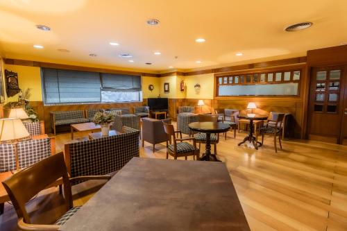 a restaurant with tables and chairs in a room at Hotel Alhama in Cintruénigo