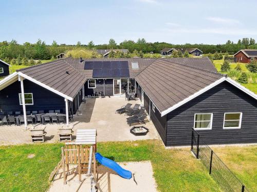 a large black building with a playground in front of it at Luxury Retreat by Beach - By Traum Ferienwohnungen in Marielyst