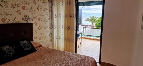 una camera da letto con un letto e una porta su un balcone di Apt. Faraj a Playa de las Americas