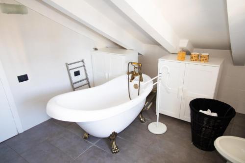 a bathroom with a white bath tub and a sink at Hosting Dreams Attics - Duomo in Milan