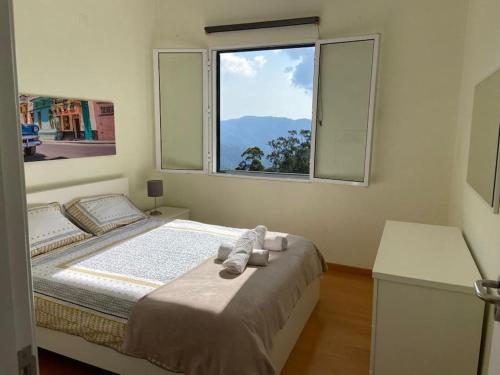 1 dormitorio con 1 cama grande y ventana en The Hideaway Retreat, en Santo da Serra