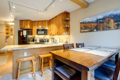 a kitchen with a large wooden table and a counter at Winter Park Ski-InandSki-Out Condo with Mountain Views in Winter Park