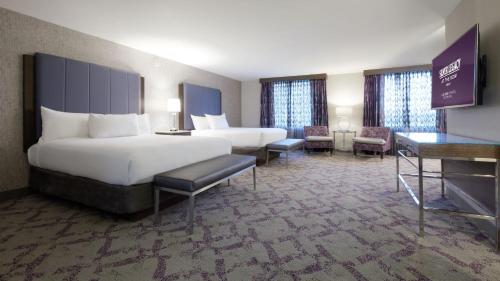 a large hotel room with two beds and chairs at Silver Legacy Reno, A Caesars Destination in Reno