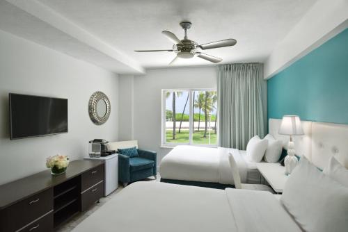 a hotel room with a bed and a tv at Beacon South Beach Hotel in Miami Beach