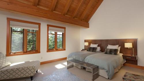 um quarto com uma cama, uma cadeira e janelas em Kadenwood 2972 - Mountain Chalet, w/ Hot Tub, Pool Table, Fireplace - Whistler Platinum em Whistler