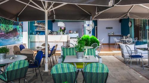 Hotel Apanema في فيفاري: مطعم بطاولات وكراسي ومظلة