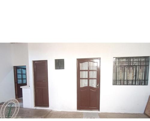two doors and two windows on a white building at Como en casa in Sucre