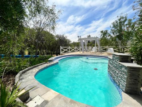 una piscina con una pared de piedra alrededor en Hermosa Casa con piscina “El Paraíso” en Viña Guzmán