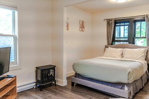 a bedroom with a bed and a fireplace and a television at Historical Building 1br 1ba Walk To Rogers Place in Edmonton