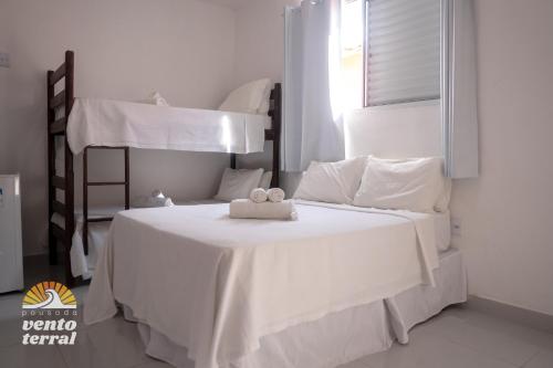 a white bed with a stuffed animal on top of it at Pousada Vento Terral in Pipa
