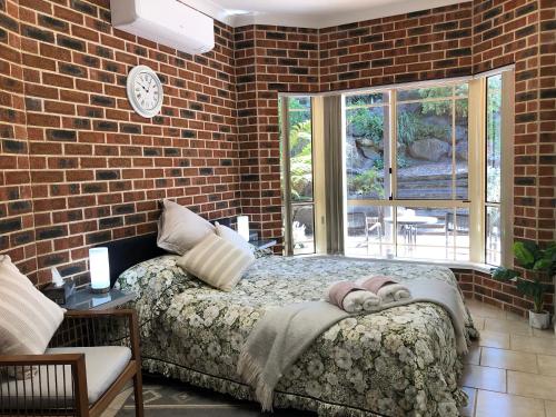 a bedroom with two beds and a brick wall at Rocky Rest in Orange