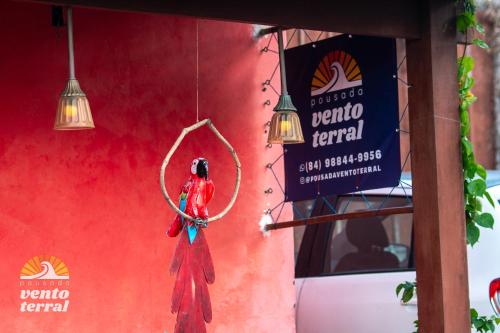 a red wall with a person hanging from a hoop at Pousada Vento Terral in Pipa