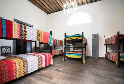a room with four bunk beds and a wooden floor at Hostal Santo Domingo in Puebla