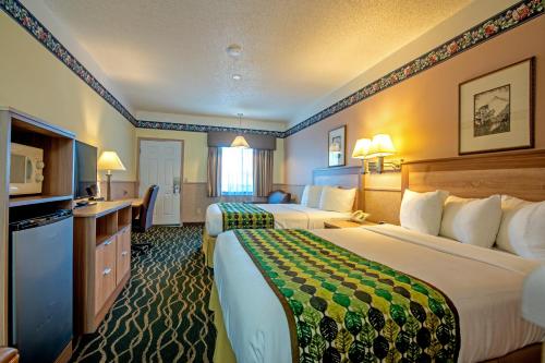 Cette chambre comprend deux lits et une télévision. dans l'établissement Silver Spruce Inn, à Glenwood Springs