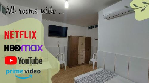 1 dormitorio con 1 cama y TV en una habitación en Amazon House Hostel en Iquitos