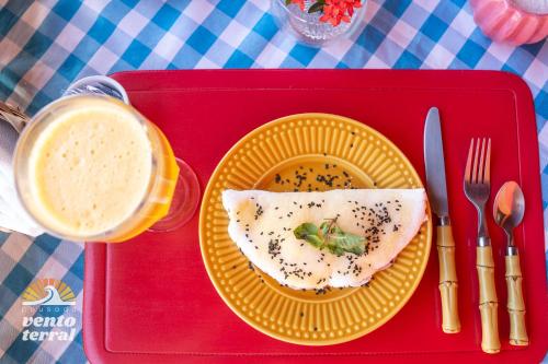 a red tray with a plate of food on a table at Pousada Vento Terral in Pipa