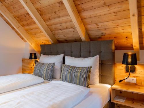 a bedroom with a large white bed and wooden ceilings at Mountain Chalet Bergfreund in Sankt Lorenzen ob Murau