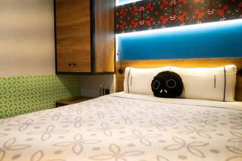 um quarto com uma cama com uma almofada de crânio em Barrio Downtown Mexico City Hostel em Cidade do México
