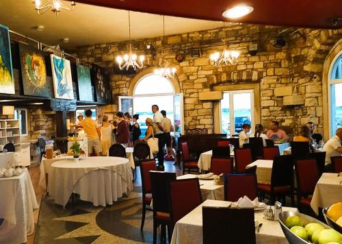 un restaurante con mesas y personas en una pared de piedra en PiranArt Boutique Hotel & More, en Piran