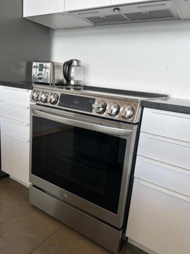 a kitchen with a stove with a pot on top of it at Magical Loft : Breathtaking View & Cozy Fireplace in Saguenay