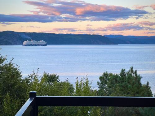 a cruise ship on a large body of water at Magical Loft : Breathtaking View & Cozy Fireplace in Saguenay
