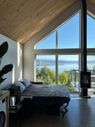 1 dormitorio con cama y ventana grande en Magical Loft : Breathtaking View & Cozy Fireplace en Saguenay